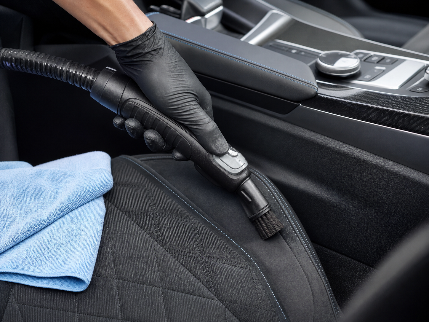 A gloved WhipKlean detailer cleaning a hard-to-reach vehicle seat seam